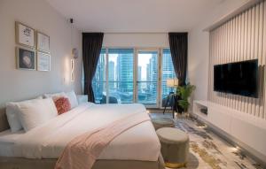 a bedroom with a large bed and a large window at Walking Distance to Metro! FULL Canal View in Dubai
