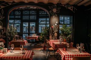 un restaurante con mesas con manteles rojos y blancos en Hotel Saint-Amour, en Durbuy