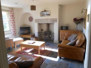 - un salon avec un canapé et une cheminée dans l'établissement Rustic cottage, garden, near amenities, wifi, à Pateley Bridge