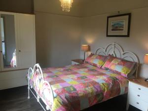 - une chambre dotée d'un lit avec une couette colorée et 2 chaises dans l'établissement Rustic cottage, garden, near amenities, wifi, à Pateley Bridge