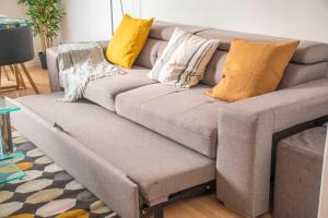 un sofá con almohadas en la sala de estar en Apartment Villeneuve Stade de France Free parking WiFi, en Villeneuve-la-Garenne