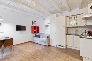 een keuken en een woonkamer met een bank bij JOIVY Beautiful Studio for 2 near Sempione Park in Milaan