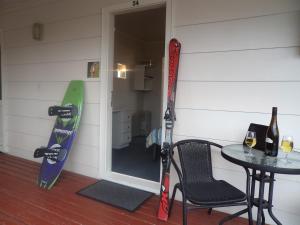 una habitación con una mesa y esquís apoyados en una pared en Tongariro Holiday Park en National Park