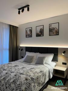 ein Schlafzimmer mit einem großen Bett mit vier Bildern an der Wand in der Unterkunft APARTAMENTY SZYNDZIELNIA RODZINNE - 2 SYPIALNIE & BALKON & GÓRY & Parking - TWOJA BAZA WYPADOWA NA SZLAKI i W GÓRY - FAMILY SPACE & BASE in Bielsko-Biała
