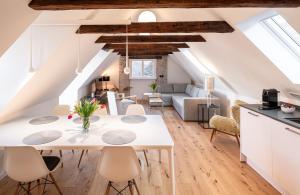 eine Küche und ein Wohnzimmer mit einem weißen Tisch und Stühlen in der Unterkunft Nicolai Suite - Schrangen-Suites-1389 in Lüneburg
