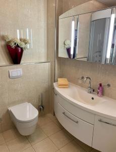 Un baño con lavabo, inodoro y espejo. en Apartments am Wasser by Fewo & Zimmer Bruns, en Emden