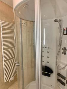 una ducha con puerta de cristal en un baño en Apartments am Wasser by Fewo & Zimmer Bruns, en Emden