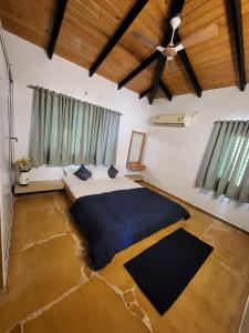 1 dormitorio con 1 cama grande y ventilador de techo en EZE NOF - A hilltop villa with 360º water view, en Nashik