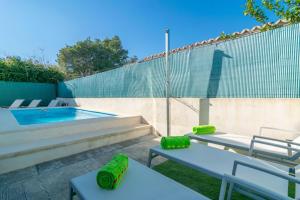 a backyard with a swimming pool with two chairs and a table at Casa Blanca -Port d'Alcudia- in Port d'Alcudia