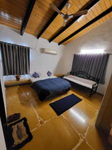 un dormitorio con una cama y algunas alfombras en ella en EZE NOF - A hilltop villa with 360º water view, en Nashik