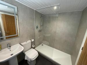 a bathroom with a toilet, sink and tub at Foundry 34 in Penrith