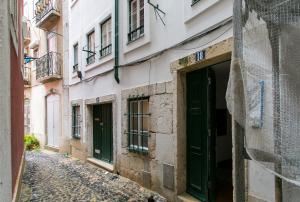 リスボンにあるBeautiful & Unique Alfamaの緑の扉のある旧市街の路地