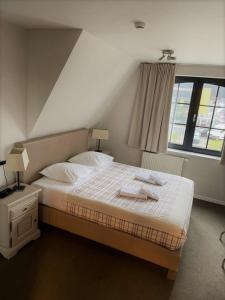een slaapkamer met een bed met twee handdoeken erop bij Hotel La Chaumiere in Asse