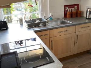 a kitchen with a sink and a counter top at Cobbler's Cottage at Kindrochet, Strathtay in Pitlochry