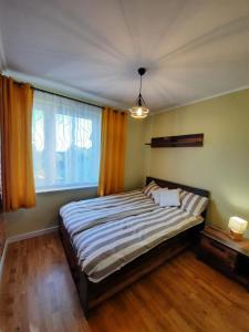 a bedroom with a large bed and a window at Domek Przy Osadzie in Bieliny