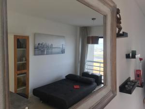 a mirror in a room with a couch and a chair at Hermoso departamento con vista al mar in Mar del Plata