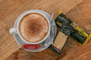 a cup of coffee on a table next to a bag of chocolate at Skegness The Royal Hotel in Skegness