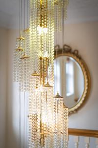 a chandelier with white beads and a mirror at Skegness The Royal Hotel in Skegness