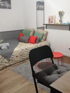 een woonkamer met een bank en kleurrijke kussens bij L'INDUSTRIEL in Orléans
