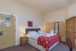 a bedroom with a bed with a red blanket on it at Skegness The Royal Hotel in Skegness