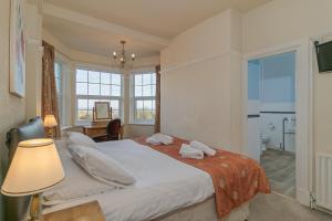 a bedroom with a bed with a lamp and a bathroom at Skegness The Royal Hotel in Skegness