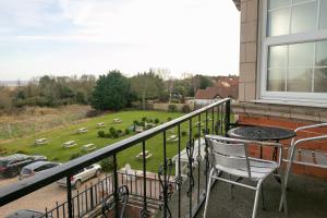 a balcony with a table and a chair and a field of sheep at Skegness The Royal Hotel in Skegness