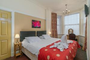 a bedroom with a large bed with a red blanket at The Royal Hotel in Skegness