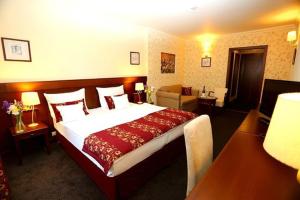 a bedroom with a large bed in a hotel room at Oroszlános Borhotel in Tállya