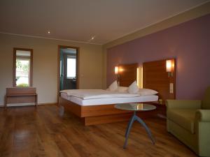 a bedroom with a bed and a couch and a table at Gästehaus Reßler in Harxheim +19 photos
