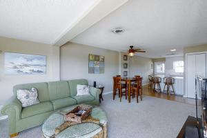 ein Wohnzimmer mit einem grünen Sofa und einem Tisch in der Unterkunft Sailing Away in Atlantic Beach