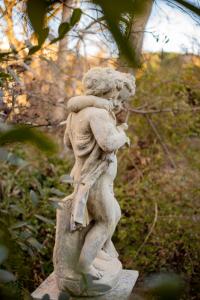 une statue d'une femme tenant un parapluie dans l'établissement Le Vieux Moulin, à Jouques