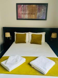 a bed with two towels sitting on top of it at Bloomsbury Palace Hotel in London