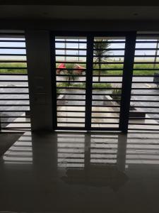 Hermoso departamento con vista al mar في مار ديل بلاتا: غرفة بها نافذتين تطل على مبنى