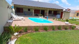 a swimming pool in the backyard of a house at Casa ,piscina há 100 metros do mar ,24 pessoas in Capão da Canoa