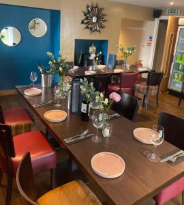 un comedor con mesas y sillas y copas de vino en Foundry 34 en Penrith