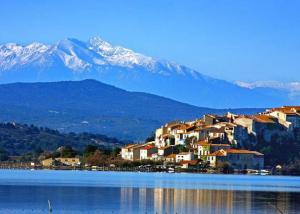 a town on the shore of a lake with mountains at Escapades ensoleillées Climatisation Télévision in Sigean