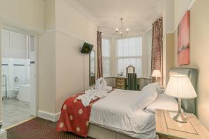 a bedroom with a bed and a bathroom with a tub at Skegness The Royal Hotel in Skegness