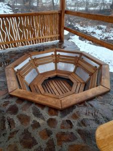 un banc en bois installé au-dessus d'un sol en pierre dans l'établissement соколів камінь, à Novoselitsa