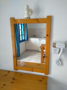 a small kitchen with a mirror on the wall at Creta Sun Hotel Studios in Agia Pelagia +59 photos