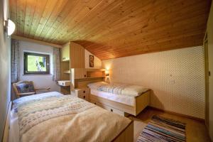a bedroom with two beds and a wooden ceiling at Traditional Apartment Trebe in Ortisei