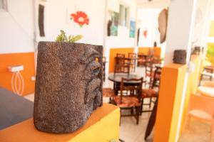 a statue of a hand holding a plant in a room at St. James Guesthouse in Roseau