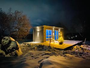 a tiny house in the snow at night at Ambarcasa Farm - Дом для уединения in Kalman'