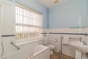 a bathroom with a tub and a toilet and a sink at Skegness The Royal Hotel in Skegness