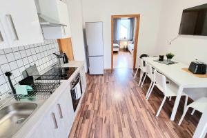 a kitchen with white appliances and a wooden floor at 3 room apartment in Hagen Eilpe in Hagen