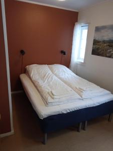 Bett in einem Zimmer mit Fenster in der Unterkunft Pilegrimsgården Hotell og Gjestegård in Trondheim