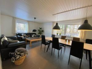 sala de estar con sofá, mesa y sillas en Camp Nørager, en Avlum