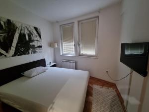 Un dormitorio con una gran cama blanca y una ventana en Apartman Veselinovic Free PARKING en Vranje