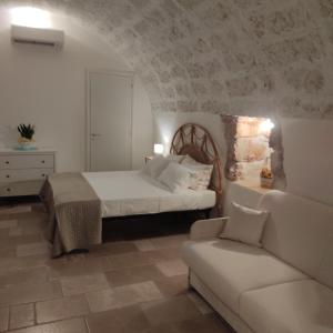 a bedroom with a bed and a couch at Liama sull'Aia in Marina di Pescoluse