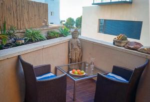 a patio with two chairs and a table and a statue at Jaffa sea front, luxury Duplex, Port & Old City 2m walk in Tel Aviv