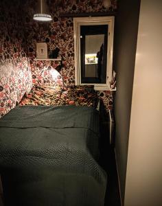 ein kleines Schlafzimmer mit einem Bett und einem Spiegel in der Unterkunft Boka Borgafjäll in Borgafjäll